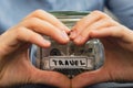 Unrecognizable woman showing heart sign Saving Money In Glass Jar filled with Dollars banknotes. TRAVEL transcription in Royalty Free Stock Photo