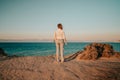 Unrecognizable woman standing near cliff over Mediterranean Ionian sea. Lady watching beautiful blue water surface alone Royalty Free Stock Photo