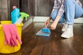 Unrecognizable woman sweeping Dust with brush and dustpan, holding broom and sweeping floor, collecting dust into