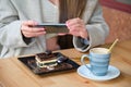 Unrecognizable woman taking photo of cake with her phone before eating it. Royalty Free Stock Photo