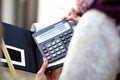 Unrecognizable woman in upper garments making calculations using calculator, measuring tape writing notes on notebook. Royalty Free Stock Photo