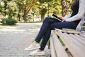 Unrecognizable woman typing on tablet outdoors