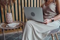 Unrecognizable woman using laptop sitting on chair at home office