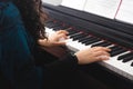 Unrecognizable woman& x27;s hands playing piano by reading sheet music. Selective focus Royalty Free Stock Photo