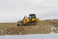 Unrecognizable worker driving industrial bulldozer heavy-duty machinery