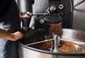 An unrecognizable worker open a industrial coffee roasting machine Royalty Free Stock Photo