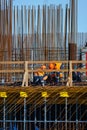 Unrecognizable workers on bridge near metal poles