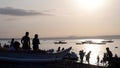 Unrecognizable young active people enjoy swimming in the shallow waters of the sea during the hot summer. Silhouettes, blurs