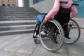 Unrecognizable young black paraplegic woman in wheelchair cannot go up stairs without ramp, feeling limited and unhappy