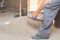 Unrecognizable young builder sieving sand at a construction site. Royalty Free Stock Photo