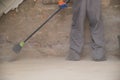 Unrecognizable young builder sweeping the floor at a construction site. Royalty Free Stock Photo