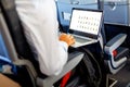 Unrecognizable young businessman with notebook sitting inside an airplane Royalty Free Stock Photo