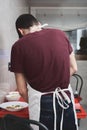 Unrecognizable young caucasian man in apron cooking in a kitchen