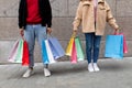 Unrecognizable young couple holding shopper bags, posing in front of stone wall outdoors, going shopping together Royalty Free Stock Photo