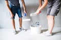 Unrecognizable young couple painting walls in their new house. Royalty Free Stock Photo