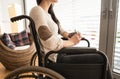 Unrecognizable young disabled woman in wheelchair at home. Royalty Free Stock Photo