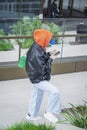 Unrecognizable young girl in jacket with hood using smartphone. Modern technology. Regular people, public places Royalty Free Stock Photo