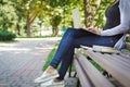 Cropped shot of young brunette woman on a bench, working with laptop in the park Royalty Free Stock Photo