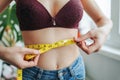 Unrecognizable young girl woman on diet measures her waist with centimeter tape. Royalty Free Stock Photo