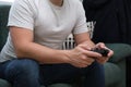 Unrecognizable young man playing video games with a gamepad sitting on sofa Royalty Free Stock Photo
