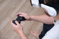 Unrecognizable young man playing video games with virtual reality headset and a gamepad sitting on sofa Royalty Free Stock Photo