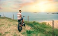 Young man riding a fat bike looking at the beach from the coast Royalty Free Stock Photo