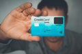 Unrecognizable young man showing card with fingerprint scanner. Close up of payment card in male hand at blur background. Next Royalty Free Stock Photo