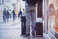 Unrecognizable young man traveling with suitcases, city street, travel and tourism concept