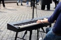 Unrecognizable young musician playing the piano and singing in the city street