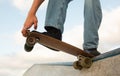 Unrecognizable young sports guy skateboarder riding at skate park with concrete walls, doing ramp tricks, closeup Royalty Free Stock Photo