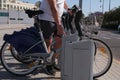 Unrecognizable young sporty man renting a bicycle from bike share stand in a city