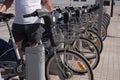 Unrecognizable young sporty man renting a bicycle from bike share stand in a city