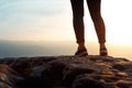 Unrecognizable young success woman hiker legs on mountain peak rock, rear view. Concept achieving goal, beginning of the path,