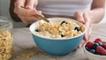 Unrecognizable young woman eating cornflakes for breakfast