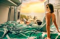 Woman with her dog watching the sunset sitting on the bed of her camper van Royalty Free Stock Photo