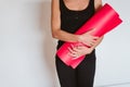 Unrecognizable Young woman listening holding yoga mat, ready to practice. Healthy lifestyle indoors Royalty Free Stock Photo