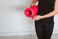 Unrecognizable Young woman listening holding yoga mat, ready to practice. Healthy lifestyle indoors Royalty Free Stock Photo