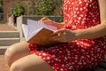 Unrecognizable Young woman in red dress Writing Gratitude Journal on wooden bench. Today I am grateful for. Self