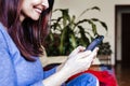 unrecognizable young woman sitting at cozy home sofa and using modern smart phone device, female hands typing text message. social Royalty Free Stock Photo