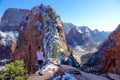 Woman stands proudly and observes the Angel\'s Landing Trail on sunny winter day.