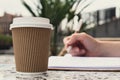 Unrecognizable Young woman study in beach resort. Drinking coffee from paper cup. Student making homework Female hands Royalty Free Stock Photo