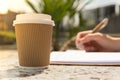 Unrecognizable Young woman study in beach resort. Drinking coffee from paper cup. Student making homework Female hands Royalty Free Stock Photo