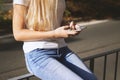 Unrecognizable young woman using smartphone mobile outside on city street