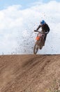 Unrecognized athlete riding a sports motorbike jumping on the air on a motocross race. Fast speed extreme sport