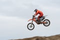 Unrecognized athlete riding a sports motorbike jumping on the air on a motocross race. Fast speed extreme sport