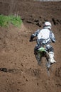 Unrecognized athlete riding a sports motorbike on a motocross racing event. Competitive sport