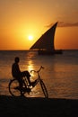 Unrecognized boy watching sunset sitting on his bicycle