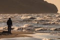 Unrecognized human watching stormy waves on Baltic Sea. Golden hour Royalty Free Stock Photo