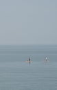 Unrecognized people canoeing in the sea in the morning. People exercising in the ocean Royalty Free Stock Photo