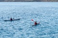 Unrecognized people canoeing in the sea in the morning. People exercising in the ocean Royalty Free Stock Photo